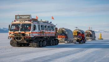 Машина и снегоходы припаркованы у кромки льда перед выездом в лагерь